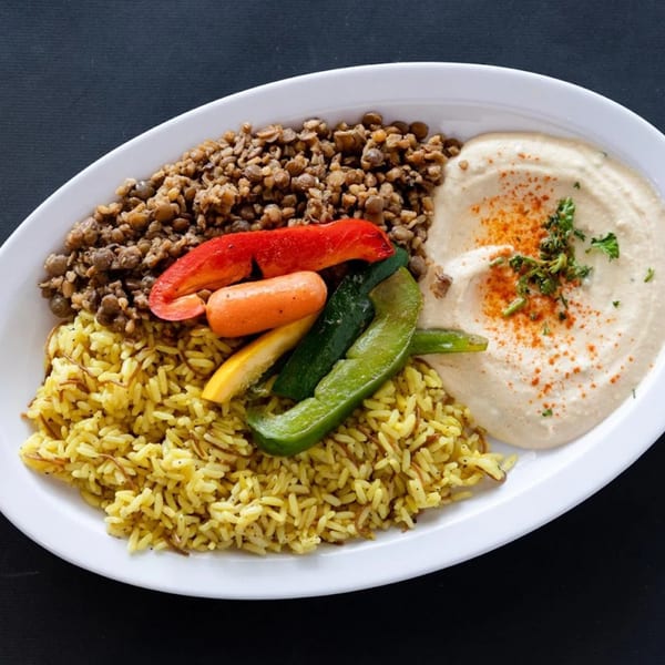 A Sultan's Restaurant Mediterranean platter with lentils, rice, hummus, and roasted vegetables.